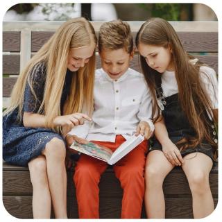 Kids beim Lesen eines Buches. Link zu unserem Onlineschaufenster Coole Bücher ab 10.