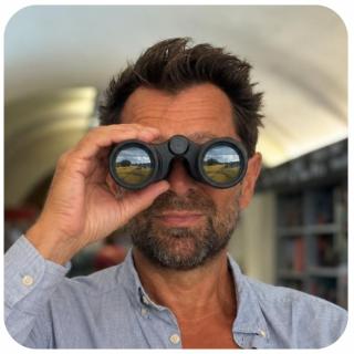 Stephan mit Fernglas. Link zu unserem Onlineschaufenster Neue Bücher, auf die wir uns schon freuen.
